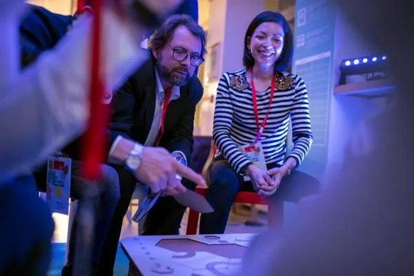 A man and a woman sitting at a table, playing a board game. A man and a woman sitting at a table, playing a board game together, smiling and concentrating.