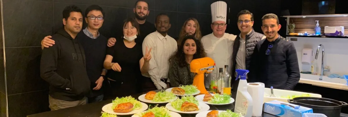 emlyon’s International MBA has enriched my perspective both towards the business world and on a personal level. A group of smiling people taking a photo in front of a wall.