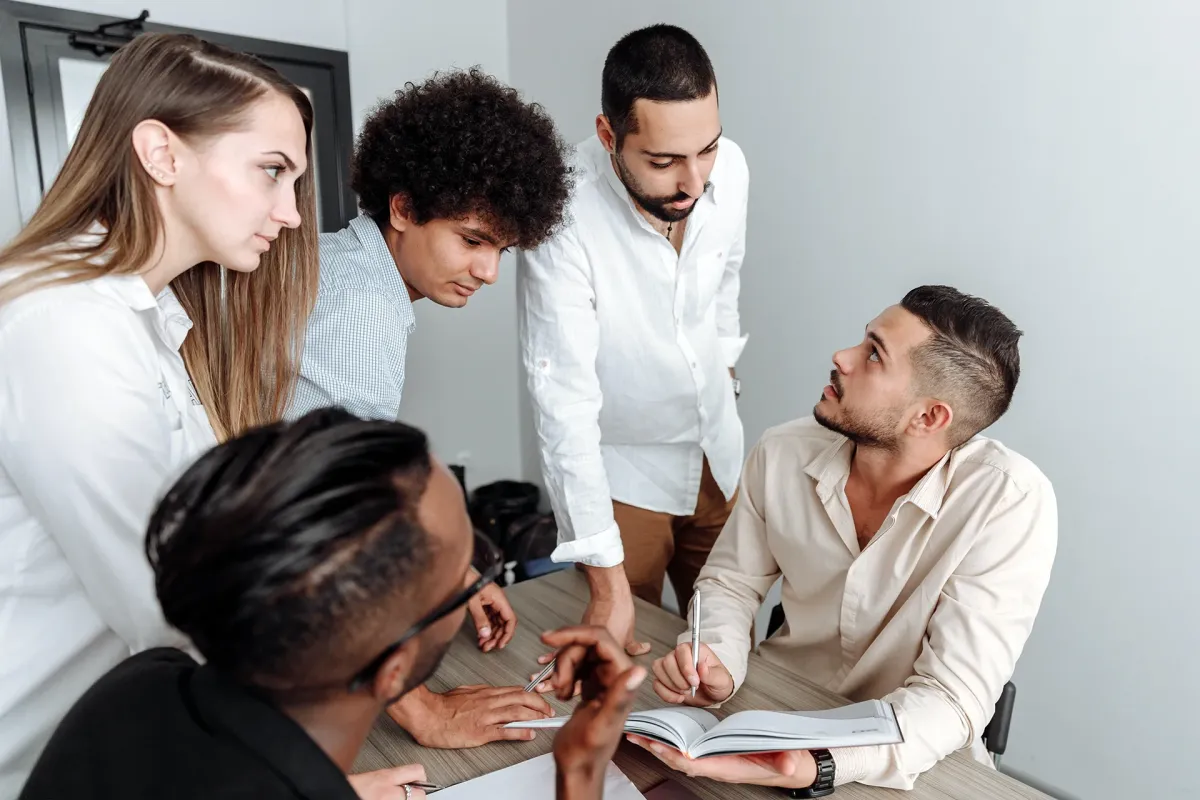 Groupe d’étudiants travaillant ensemble autour d’une table lors d’une séance de travail en équipe.
