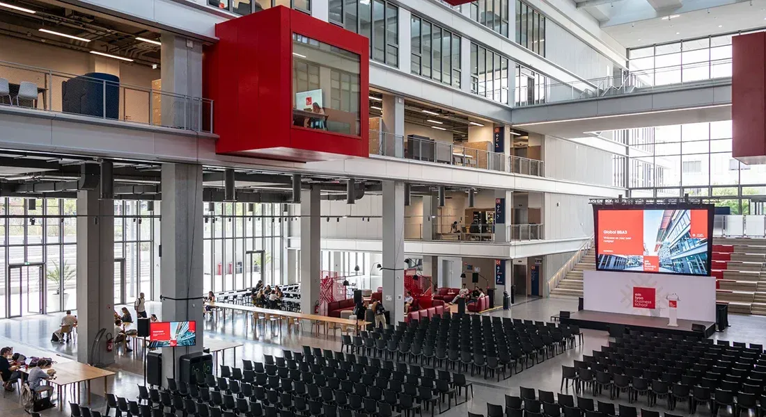 Large modern central hall at emlyon business school set up for a conference with stage and screen