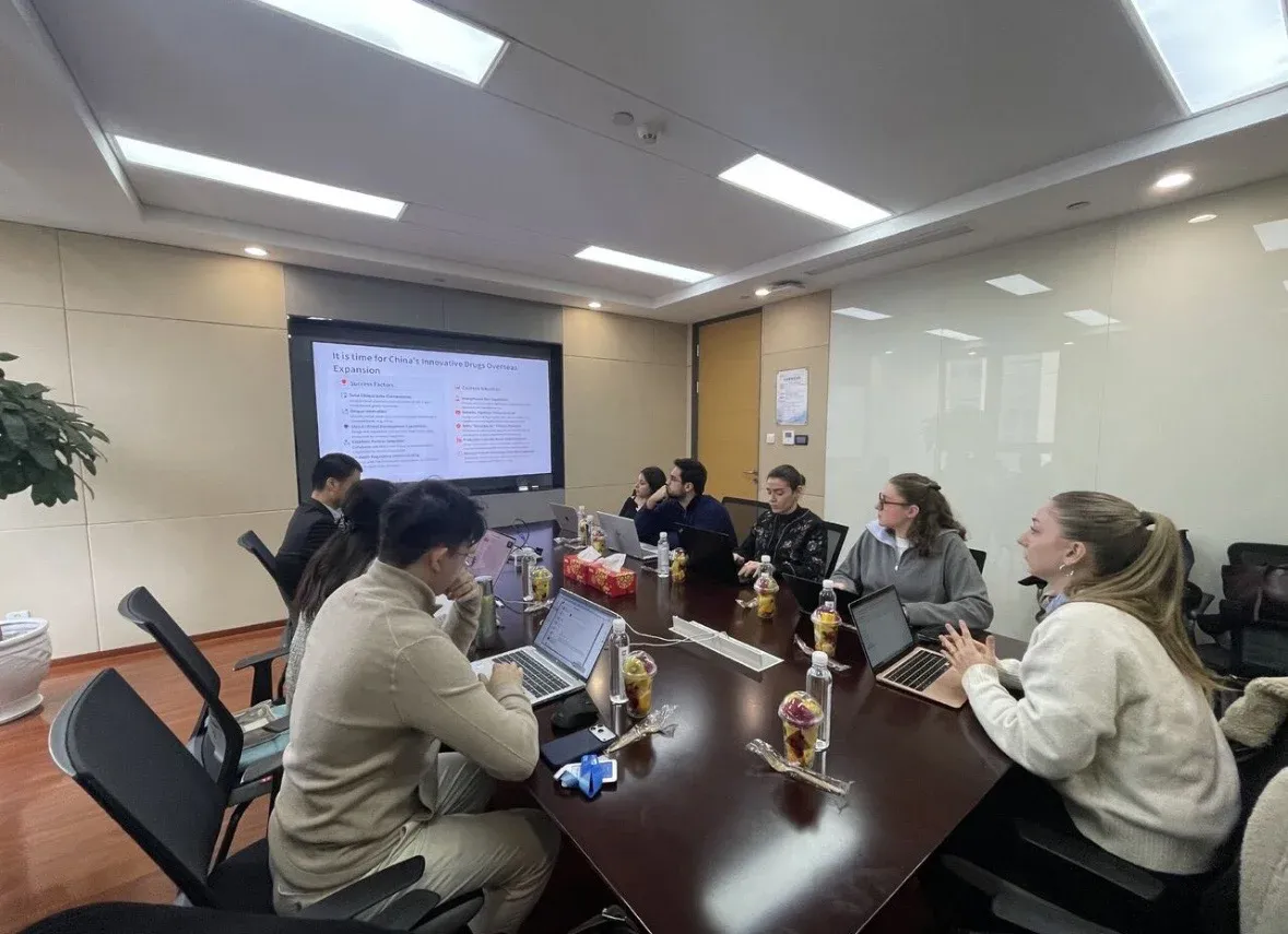 Students from the MSc in Healthcare Innovation & Data Science working in a conference room, collaborating on laptops while viewing a projected presentation.