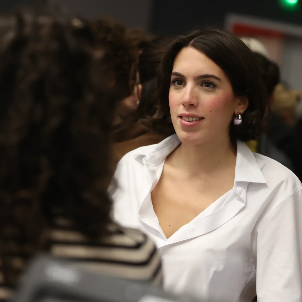 Personne échangeant avec une autre personne dans un espace intérieur du campus de Lyon, lors d’un événement ou d’une interaction professionnelle.