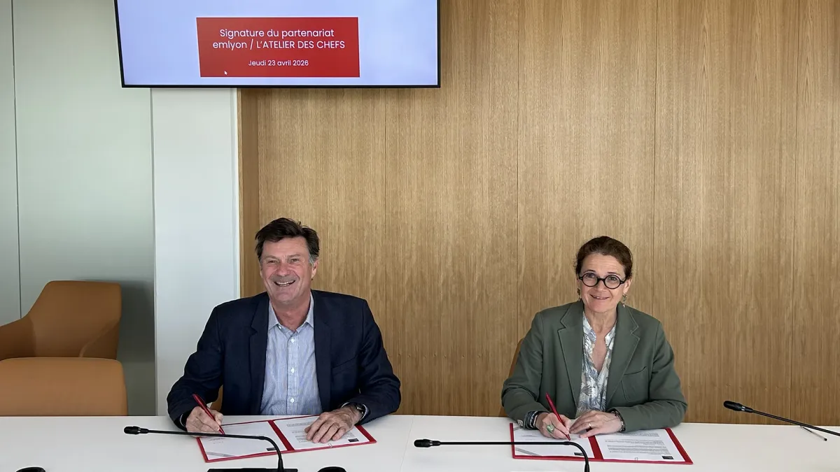 Signature du partenariat entre emlyon business school et L’atelier des Chefs lors d’une cérémonie officielle, avec deux représentantes et représentants signant les documents.