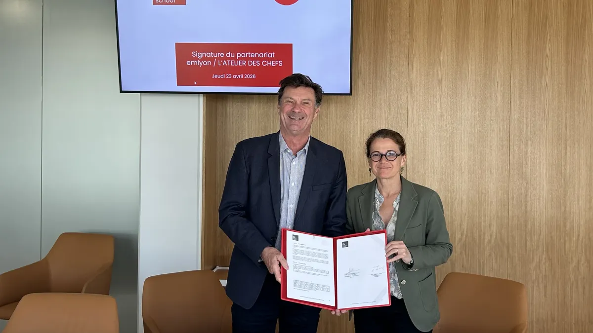  Two representatives standing and presenting a signed partnership agreement during a formal event.