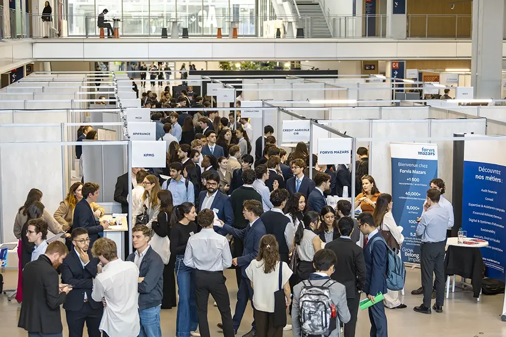Participants talking at company stands during the Finance & Consulting Forum at emlyon business school.