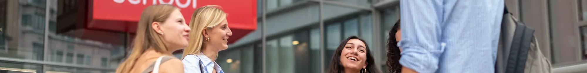 Des étudiantes et étudiants d'emlyon business school, devant l'entrée sur avenue Jean Jaurès