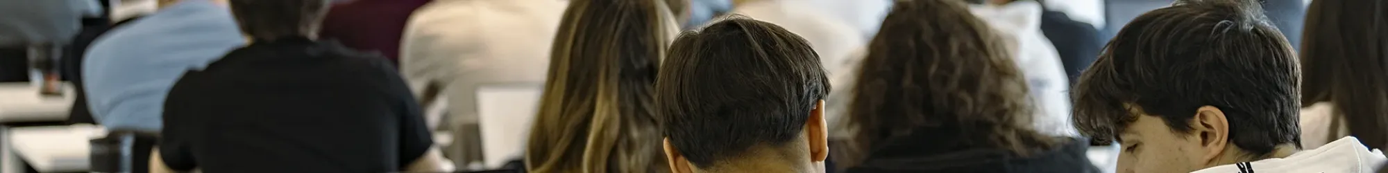 Étudiant·e·s du programme MSc d’emlyon business school assistant à un cours, avec ordinateurs portables et présentation projetée à l’écran.