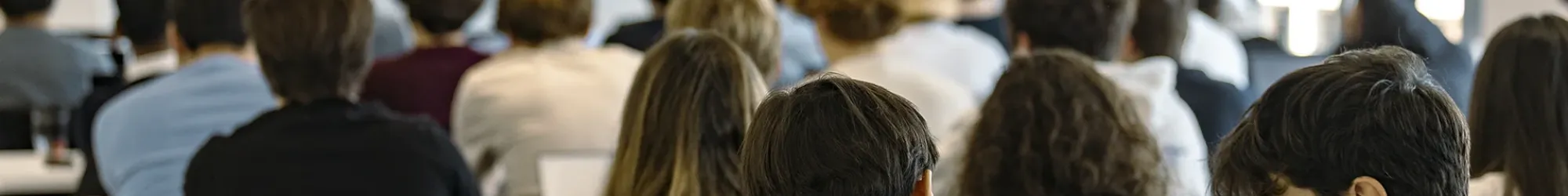 MSc students at emlyon business school attending a lecture in a classroom, using laptops while a presentation is displayed on screen.