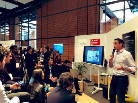 Un homme présente un discours devant une foule attentive, illustrant l'engagement et l'interaction du public.