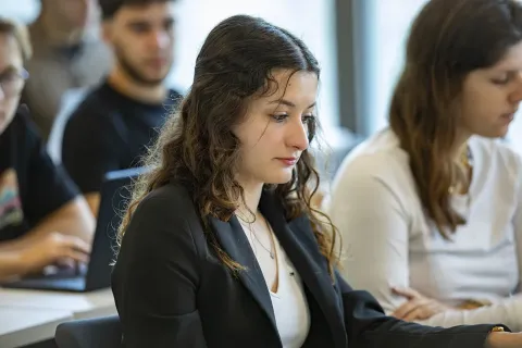 Salle de formation avec des participants suivant un cours et prenant des notes.