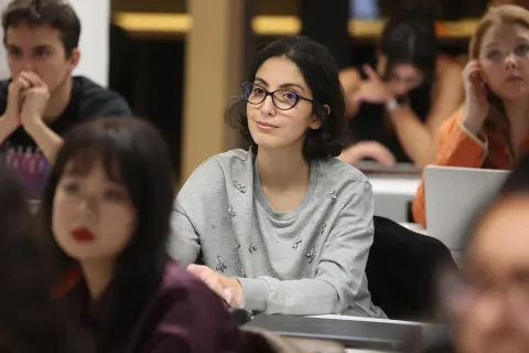 Group work session from the emlyon business school MSc program with students discussing around a laptop.
