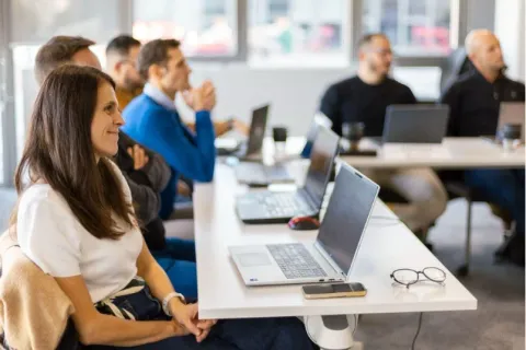 Participants à un executive master en management suivant un cours en présentiel avec ordinateurs portables, emlyon business school