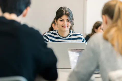 Étudiantes et étudiants du Programme Grande École (Master in Management) d’emlyon, assis en salle de cours et travaillant sur des ordinateurs portables.