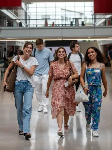 Groupe d'étudiantes et d’étudiants d'emlyon marchant à travers le cœur battant de l’école