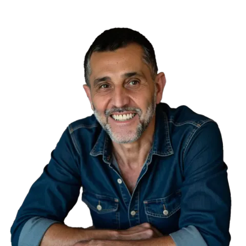 Portrait photographique d’une personne appuyée sur ses bras croisés, portant une chemise en denim, sur un fond uni clair.