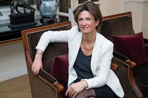 Portrait d’une personne assise dans un fauteuil en cuir dans un intérieur.