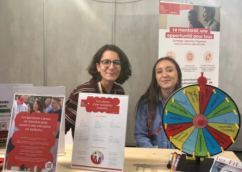 Stand consacré à la diversité et à l’inclusion lors d’un forum à emlyon business school, avec roue thématique et supports d’information.