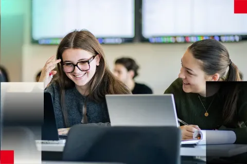 Étudiants suivant un cours avec ordinateur portable et tablette dans une salle de classe